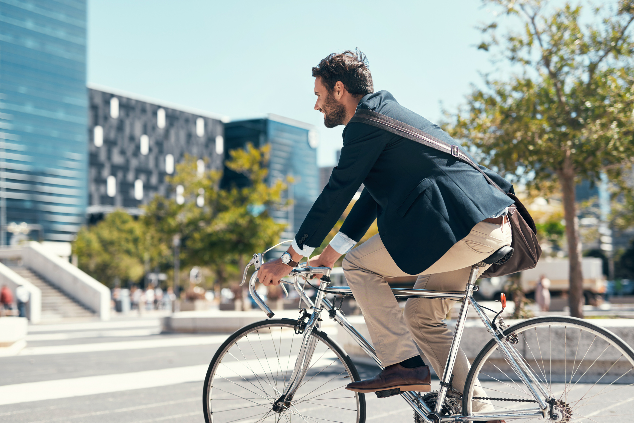                                                     Shot of a young businessman traveling through the city with his bicycle                                    