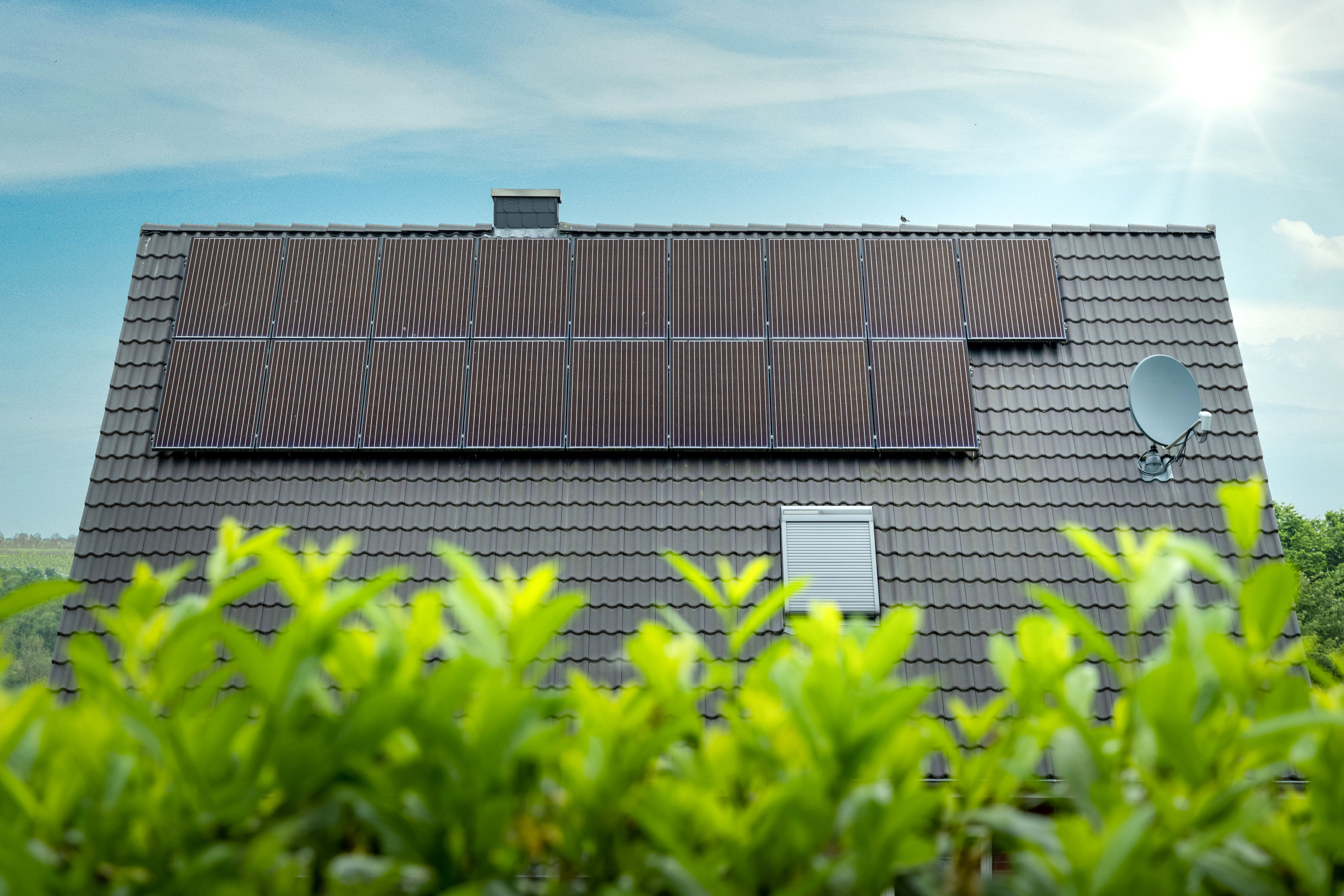                                                     Solarthermie-Kollektoren auf einem Hausdach                                    